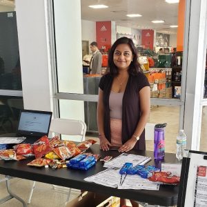 Tarika Sankar stands behind a table with flyers and snacks